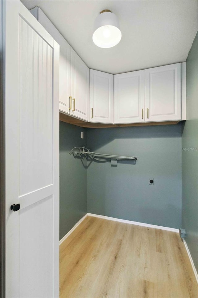 washroom with cabinets, light hardwood / wood-style flooring, and hookup for an electric dryer