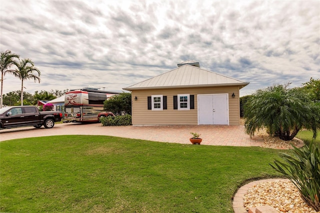 exterior space featuring a front lawn and an outdoor structure