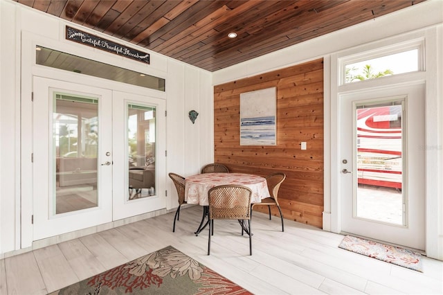 interior space with wooden ceiling, wood walls, french doors, and a healthy amount of sunlight