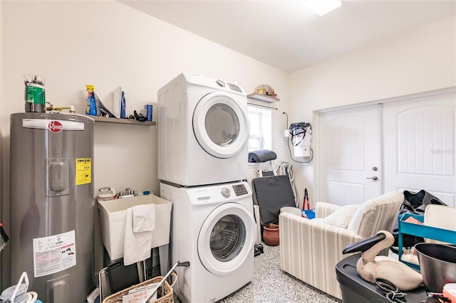 laundry area with stacked washer / dryer and water heater