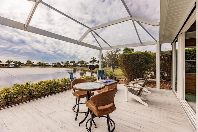 view of patio / terrace with a lanai and a water view