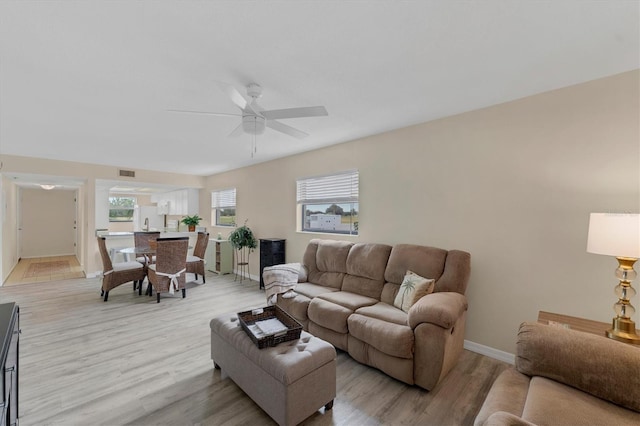 living room featuring ceiling fan and light hardwood / wood-style flooring