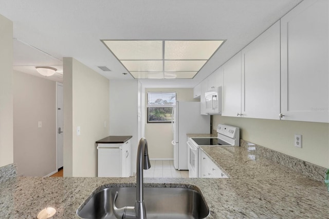 kitchen with white cabinets, light stone countertops, sink, and white appliances