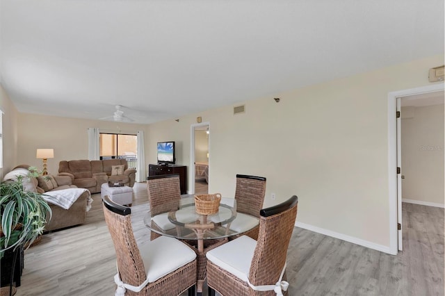 dining area with light wood-type flooring and ceiling fan