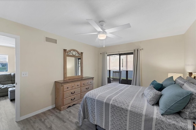 bedroom with ceiling fan, multiple windows, and light hardwood / wood-style flooring