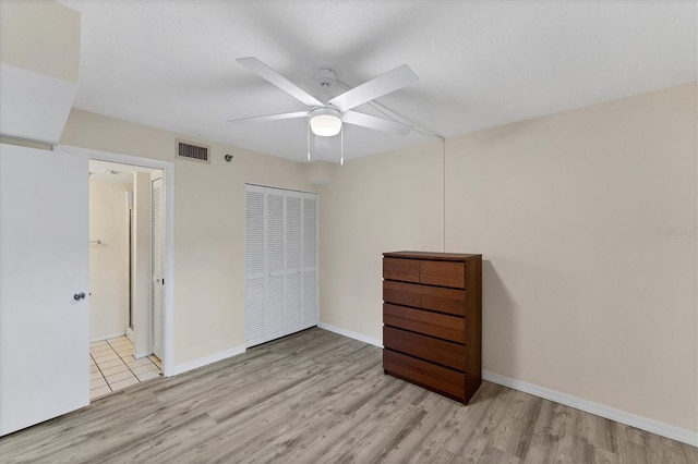 unfurnished bedroom with ceiling fan, a closet, and light hardwood / wood-style flooring