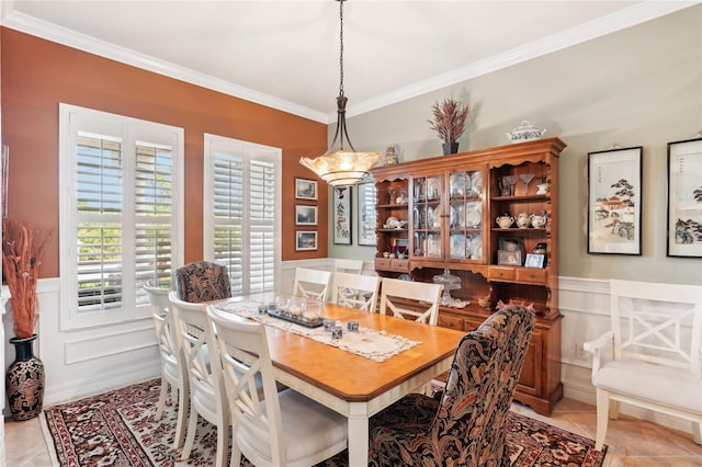 dining room with light tile patterned floors and crown molding