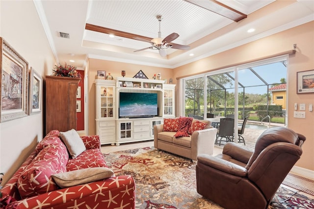 living room with ceiling fan, a raised ceiling, and crown molding