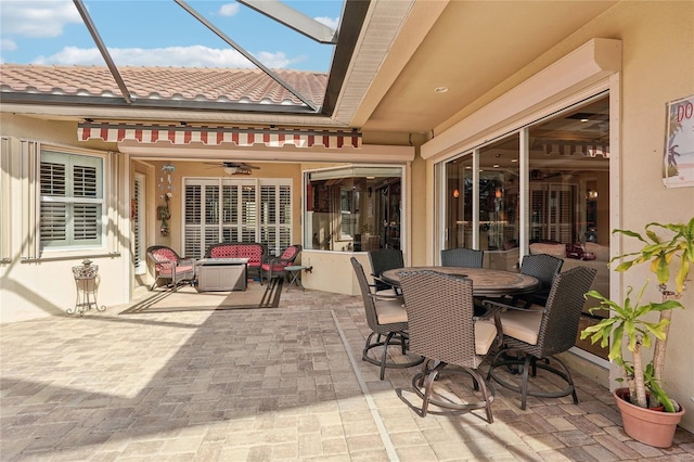 view of patio / terrace featuring ceiling fan and glass enclosure