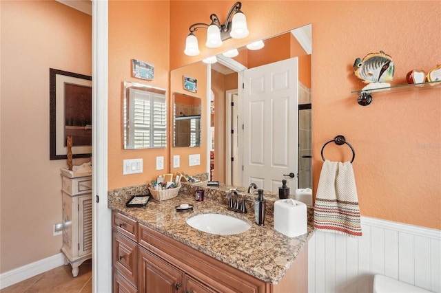 bathroom with an enclosed shower, vanity, and tile patterned flooring