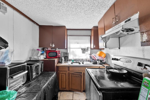 kitchen with sink, light tile patterned flooring, a textured ceiling, and electric range