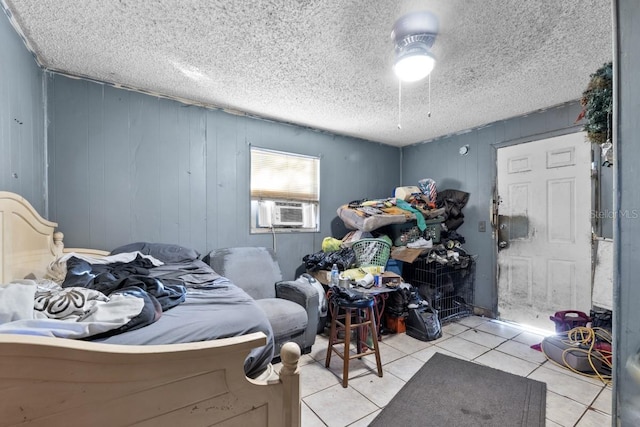 bedroom featuring cooling unit, wood walls, and light tile patterned floors