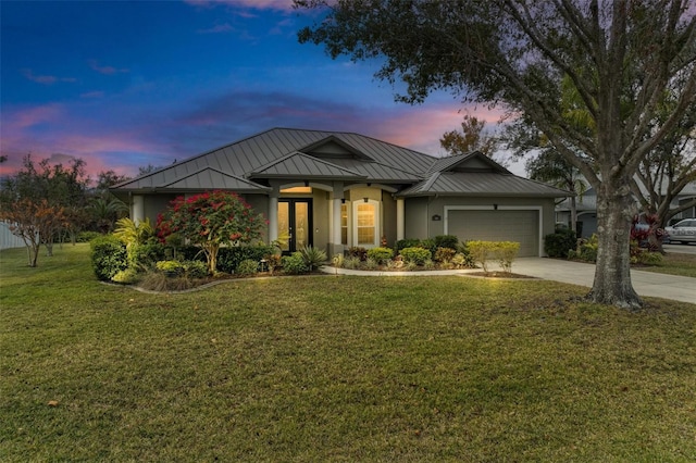 view of front of property with a yard and a garage