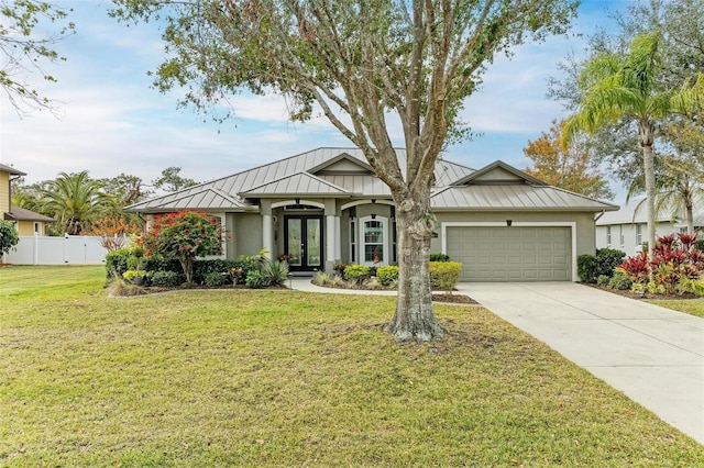 view of front of property with a front lawn, a garage, and french doors