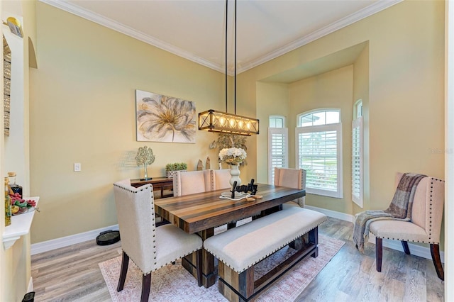 dining room featuring crown molding and light hardwood / wood-style flooring