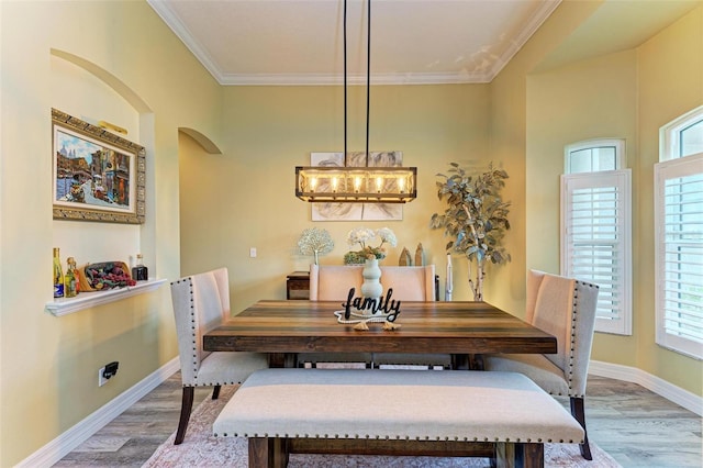 dining area with hardwood / wood-style flooring and ornamental molding