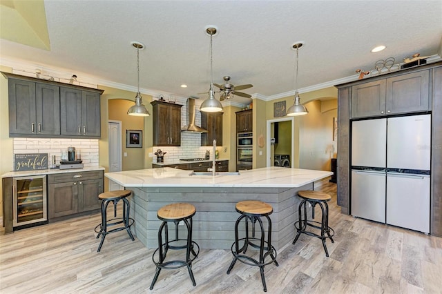 kitchen with decorative backsplash, a spacious island, appliances with stainless steel finishes, and wine cooler