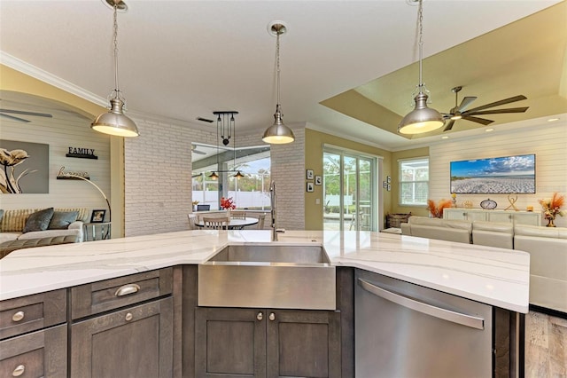 kitchen with stainless steel dishwasher, light stone counters, hanging light fixtures, and dark brown cabinetry