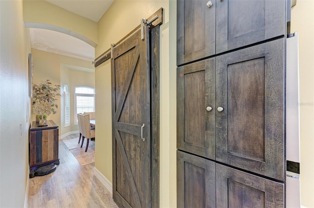 interior space with light wood-type flooring and a barn door