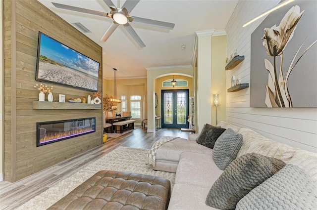 living room with a fireplace, wood-type flooring, french doors, and wooden walls