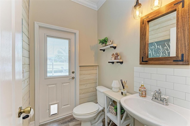 bathroom featuring tasteful backsplash, sink, toilet, hardwood / wood-style flooring, and crown molding