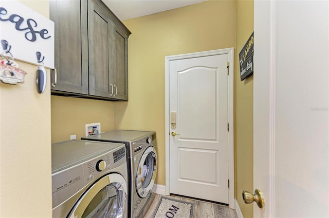 laundry area featuring light hardwood / wood-style floors, cabinets, and washer and clothes dryer