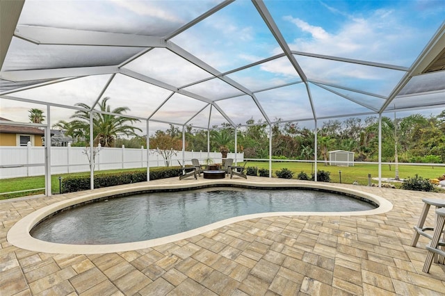 view of swimming pool featuring a patio area, a lanai, and a storage unit