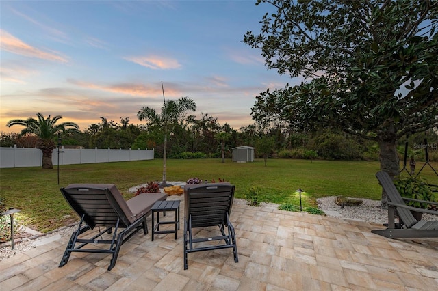 patio terrace at dusk with a shed and a yard