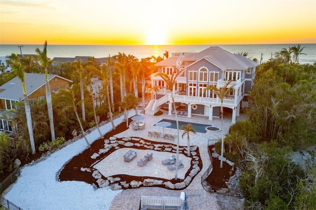 aerial view at dusk featuring a water view