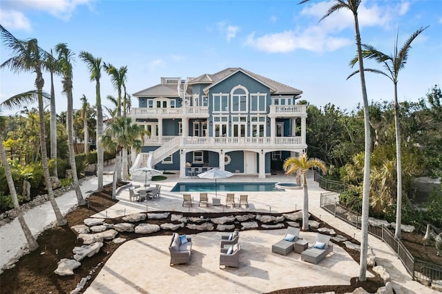 rear view of house featuring a patio area and a balcony