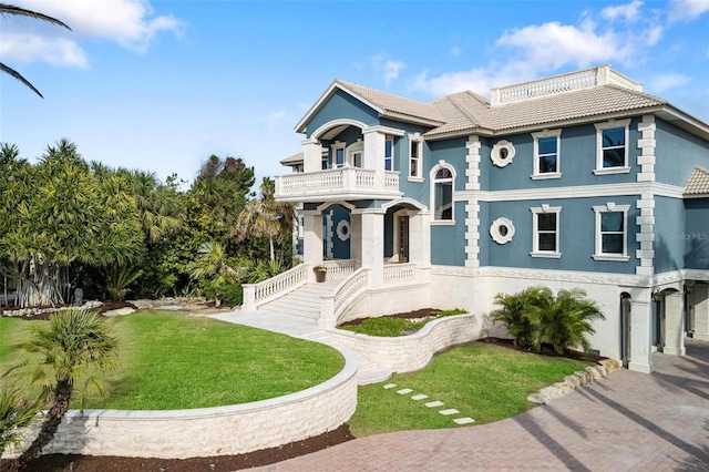 view of front of property with a balcony and a front lawn