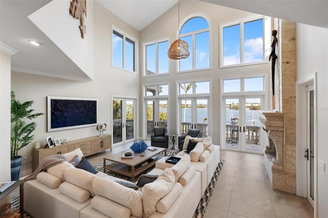 living room with a high ceiling, a water view, and french doors