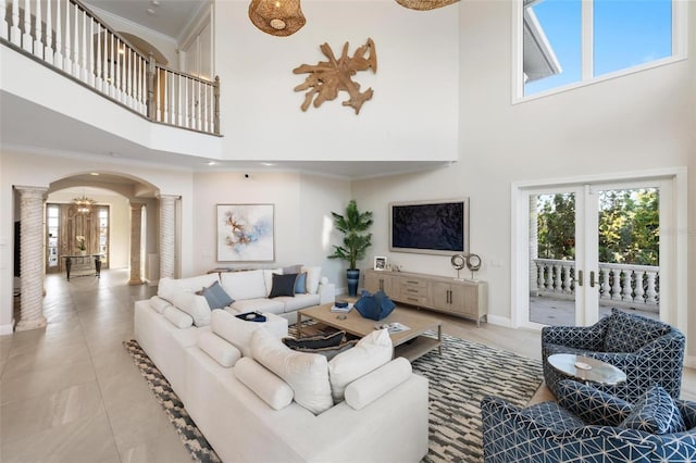 living room with crown molding, french doors, a high ceiling, and decorative columns