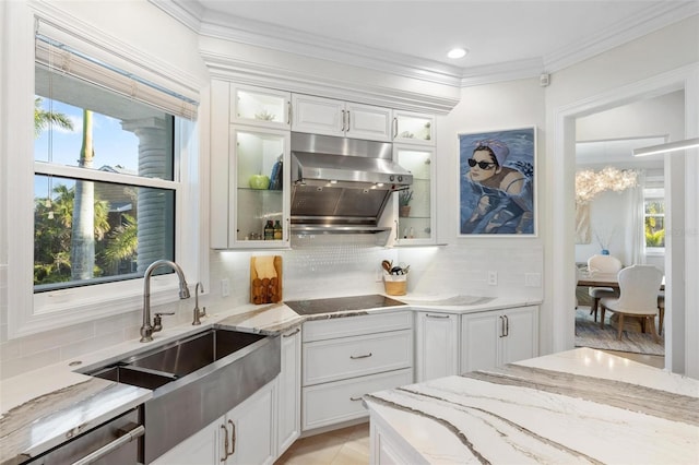 kitchen with tasteful backsplash, sink, light stone countertops, white cabinets, and black electric cooktop