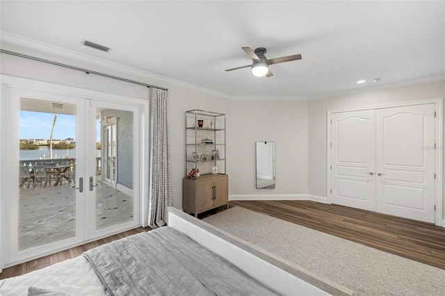 unfurnished bedroom featuring dark hardwood / wood-style flooring, french doors, access to outside, a water view, and ceiling fan