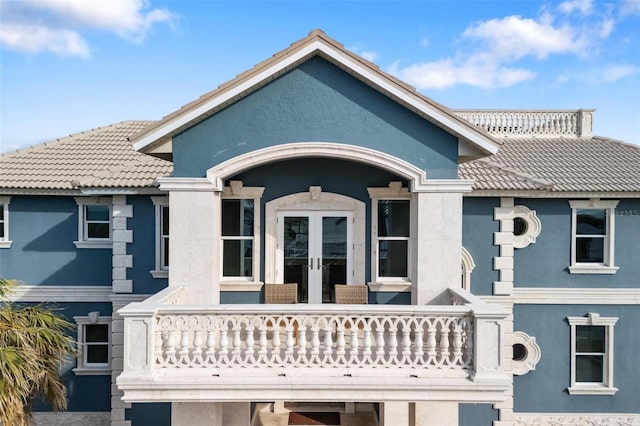 rear view of property with a balcony and french doors