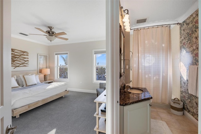 bedroom featuring ceiling fan, light carpet, sink, and crown molding