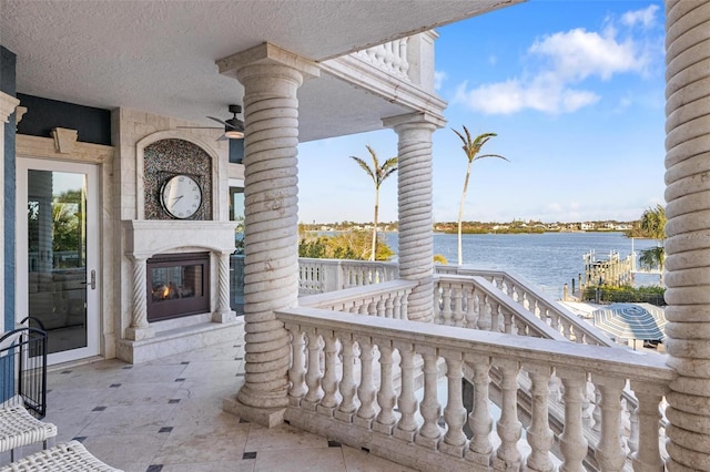 view of patio with ceiling fan and a water view