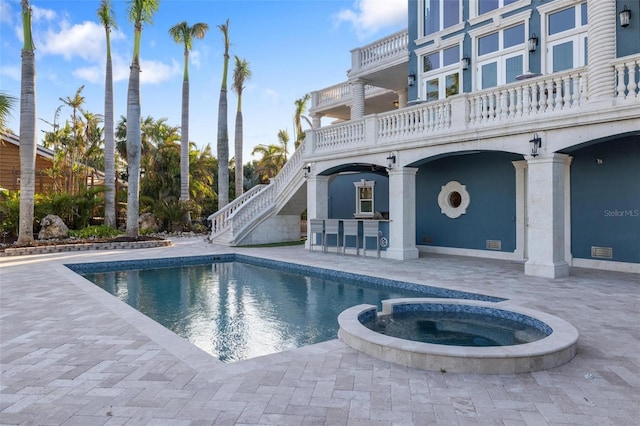 view of pool featuring an in ground hot tub, a patio area, and exterior bar