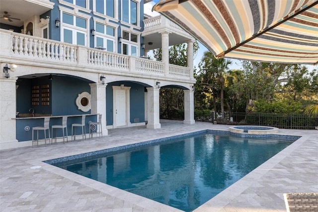 view of pool with a bar, an in ground hot tub, and a patio