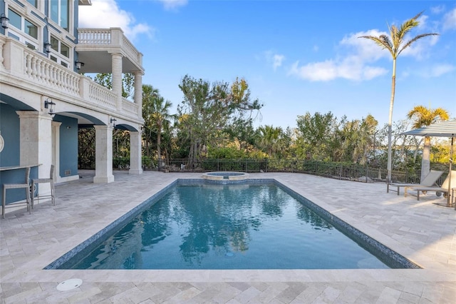 view of swimming pool with a patio and an in ground hot tub