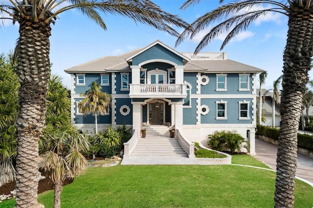 view of front facade featuring a front lawn and a balcony