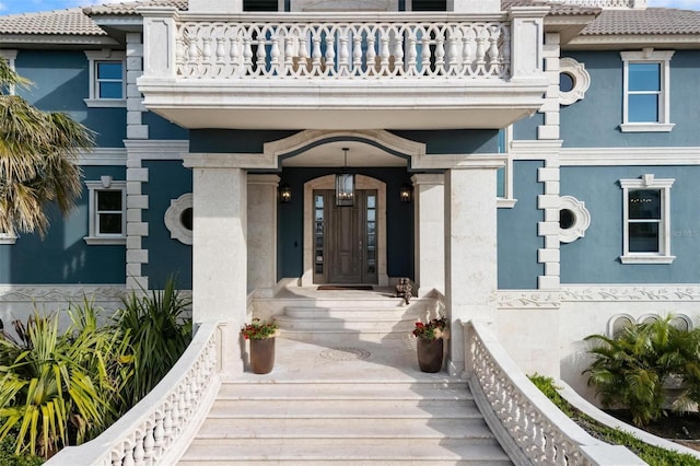 view of exterior entry with a balcony