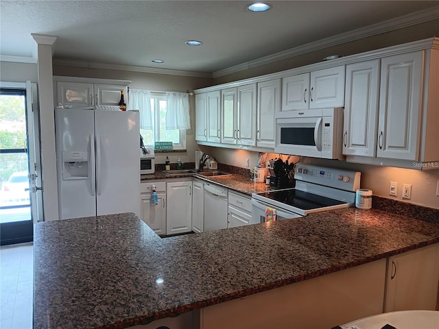 kitchen featuring kitchen peninsula, a healthy amount of sunlight, white appliances, white cabinets, and sink