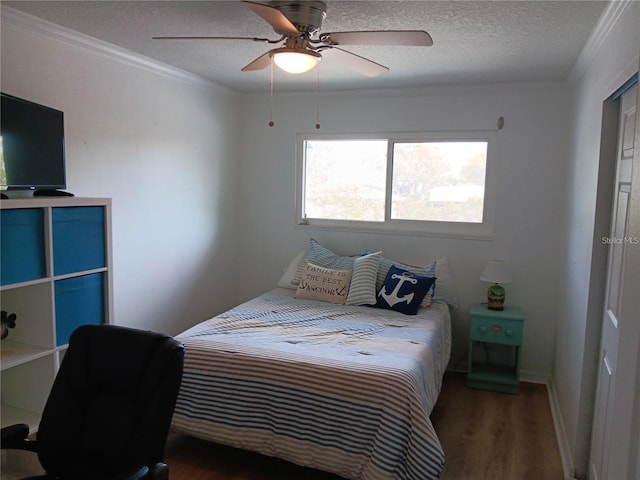 bedroom with ceiling fan, dark wood-type flooring, a textured ceiling, and ornamental molding