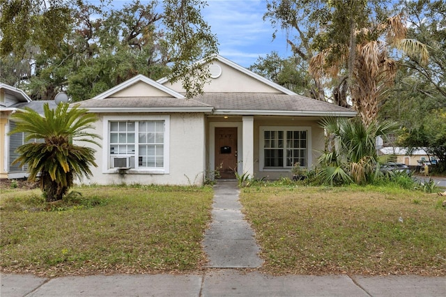 bungalow-style home featuring cooling unit and a front yard