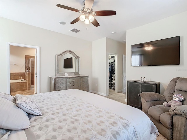 carpeted bedroom featuring a spacious closet, connected bathroom, ceiling fan, and a closet