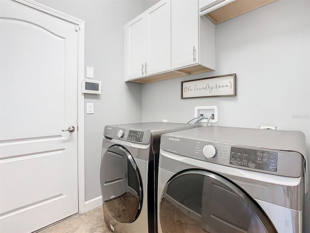 clothes washing area featuring cabinets, separate washer and dryer, and light tile patterned floors