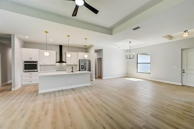 kitchen with appliances with stainless steel finishes, pendant lighting, white cabinets, and a tray ceiling