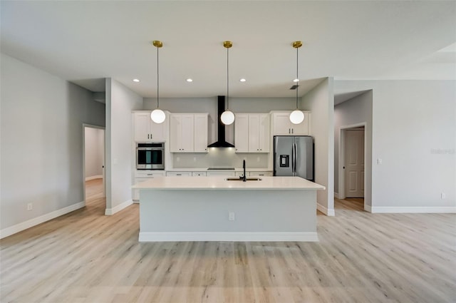 kitchen with sink, white cabinets, hanging light fixtures, stainless steel appliances, and wall chimney exhaust hood